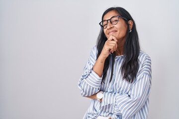 Sticker - Young hispanic woman wearing glasses looking confident at the camera smiling with crossed arms and hand raised on chin. thinking positive.