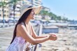 © Krakenimages.com - Young beautiful hispanic woman tourist smiling confident leaning on balustrade at seaside