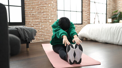 Sticker - Young chinese woman stretching legs at bedroom