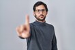 © Krakenimages.com - Handsome latin man standing over isolated background pointing with finger up and angry expression, showing no gesture
