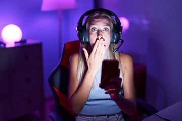 Sticker - Young caucasian woman playing video games with smartphone covering mouth with hand, shocked and afraid for mistake. surprised expression