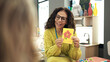 © Krakenimages.com - Middle age hispanic woman preschool teacher having vocabulary lesson at kindergarten