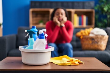 Poster - African american woman cleaner tired sitting on sofa at home