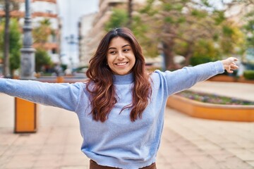 Poster - Young hispanic woman smiling confident standing with open arms at park