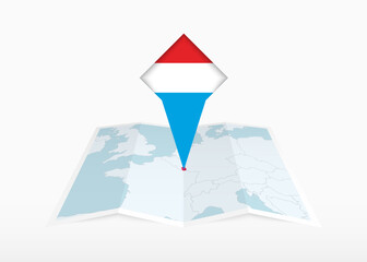 Sticker - Luxembourg is depicted on a folded paper map and pinned location marker with flag of Luxembourg.