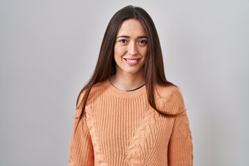 Sticker - Young brunette woman standing over white background with a happy and cool smile on face. lucky person.