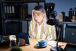© Krakenimages.com - Middle age woman with grey hair working at the office at night with hand on stomach because nausea, painful disease feeling unwell. ache concept.
