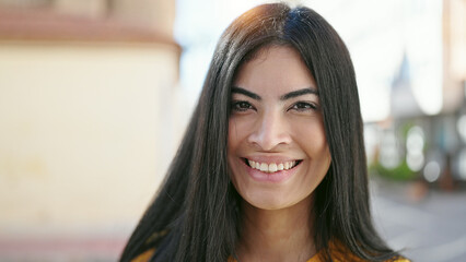 Wall Mural - Young beautiful hispanic woman smiling confident standing at street