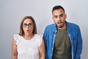 Sticker - Hispanic mother and son standing together afraid and shocked with surprise and amazed expression, fear and excited face.