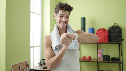 Poster - Young hispanic man smiling confident using stopwatch at sport center