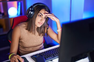 Poster - Young beautiful hispanic woman streamer stressed using computer at gaming room