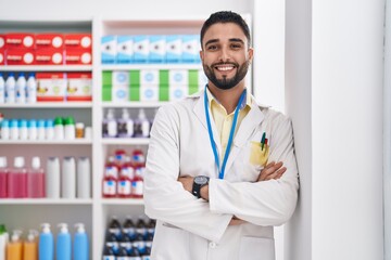 Canvas Print - Young arab man pharmacist smiling confident standing with arms crossed gesture at pharmacy