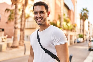 Wall Mural - Young hispanic man smiling confident standing at street