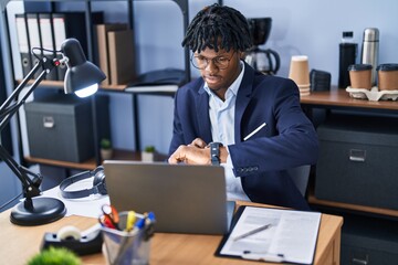 Poster - African american man business worker using laptop and looking watch at office