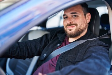 Wall Mural - Young hispanic man smiling confident driving car at street