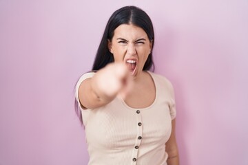 Canvas Print - Young hispanic woman standing over pink background pointing displeased and frustrated to the camera, angry and furious with you