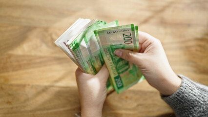 Hands of woman counting russian ruble banknotes at room