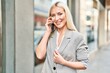 © Krakenimages.com - Young blonde woman smiling confident talking on the smartphone at street