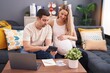 © Krakenimages.com - Man and woman couple expecting baby using laptop and calculator accounting at home