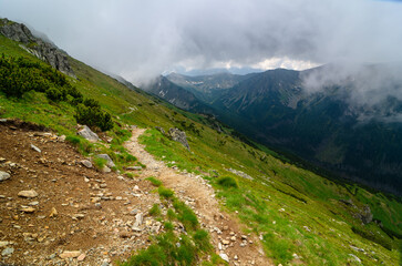 Mountain landscape with a panorama view of the peaks partly obscured by clouds.