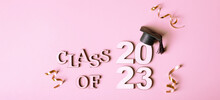 Class Of 2023 Concept. Wooden Number 2023 With Graduated Cap On Pink Background
