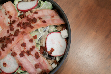 Wall Mural - Salad with bacon, croutons and lettuce close-up on a plate on a table. Classic American salad, food. Healthy Keto diet. Copy space.