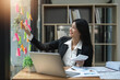 © Natee Meepian - Asian business woman working with sticky note at office ,Financial analysis and tax concept