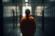 © Sergio - Woman prisoner, back view of brunette in orange uniform in prison. Generative AI