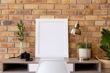 Poster - White empty frame with copy space, plants and technology devices on desk against brick wall