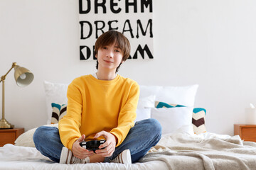 Wall Mural - Teenage boy playing video game in bedroom