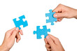 Teamwork, cooperation and partnership concept, human hands holding puzzle pieces