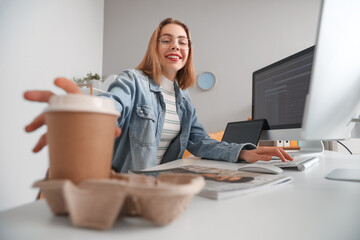 Sticker - Female programmer taking cup of coffee from table in office