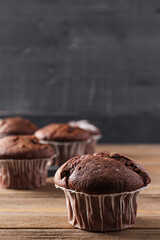 Tasty chocolate cupcakes on wooden table