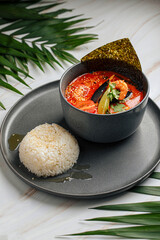 Wall Mural - Portion of thai tom yam seafood soup with rice and nori