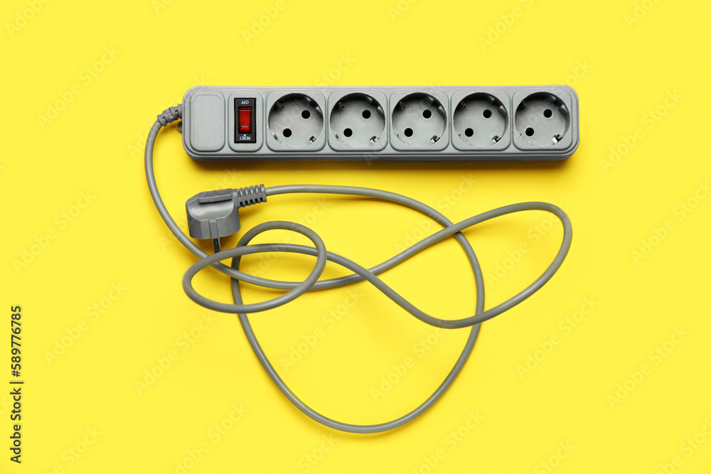 Electric extension cord on yellow background
