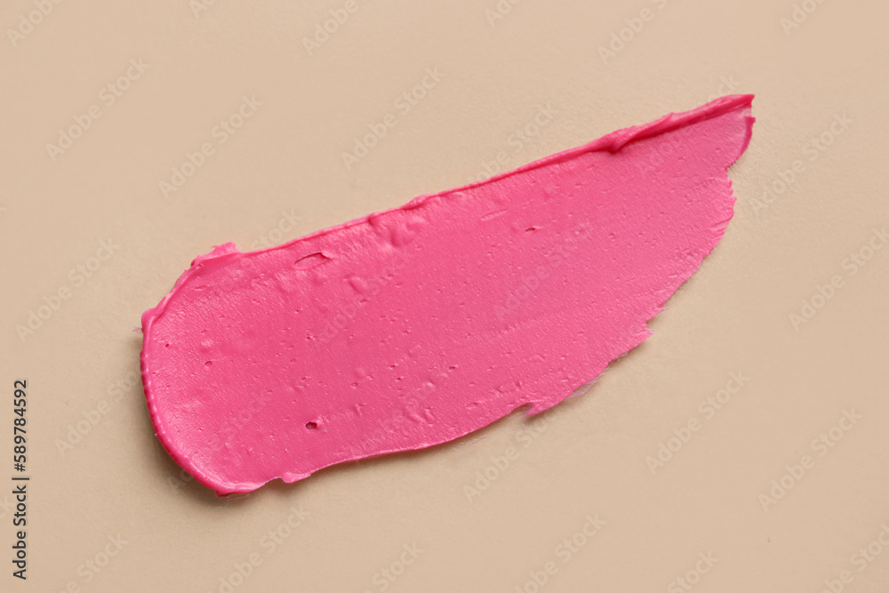 Pink lipstick stroke on beige background
