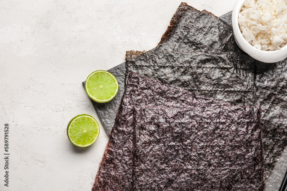 Board with nori sheets on light background, closeup