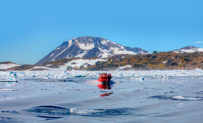 Wall Mural - fast moving motorboat trying to get out of the ice - stranded icebergs in the fog at the mouth of th