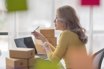 Portrait of Asian young woman SME working with a box at home the workplace.start-up small business owner, small business entrepreneur SME or freelance business online and delivery concept.
