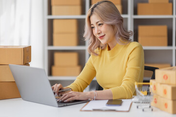 Portrait of Asian young woman SME working with a box at home the workplace.start-up small business owner, small business entrepreneur SME or freelance business online and delivery concept.
