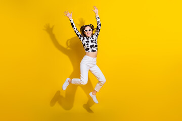 Wall Mural - Full size photo of youth lady jumping enjoy her cowgirl look wearing black spotted clothes isolated shine color background