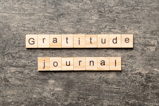 Gratitude Journal word written on wood block. Gratitude Journal text on cement table for your desing, concept