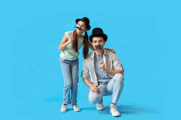 Poster - Portrait of father and his little daughter with paper mustache on light blue background