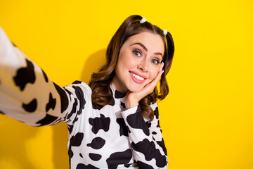 Sticker - Selfie of pretty young lovely vlogging girl touch cheek cute posing model wear stylish cow print shirt isolated on yellow color background