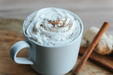 Closeup shot of a cup of hot chocolate on the wooden background