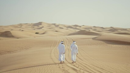 Wall Mural - Two friends making the safari in the Dubai desert. Locals with kandura white outfit spending time together on the dunes in sharjah. Concept about traveling in the united arab emirates