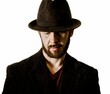 Portrait of handsome man with beard in fedora hat and blazer looking down on white background