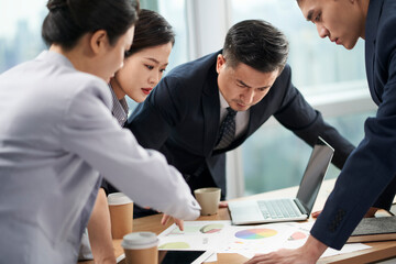 team of four asian business people meeting in office