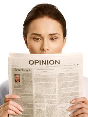 Shocked expression on a woman's face while she reads the opinion section of a newspaper