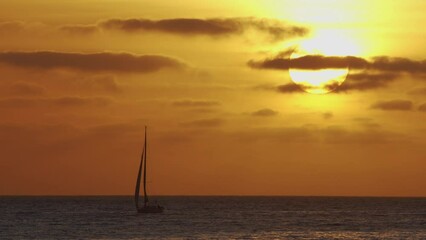 Wall Mural - beautiful evening sunset with a big sun and a sailing yacht in the atlantic ocean on the coast of po